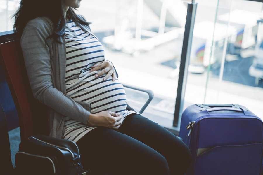 Kobieta w ciąży czeka na lotnisku